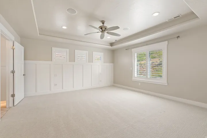 Recessed ceiling with a ceiling fan, integrated ceiling speakers, recessed lighting, and expansive carpeting