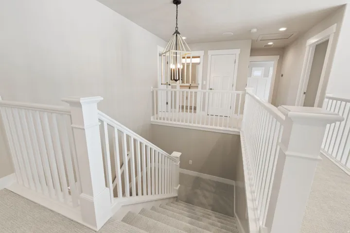 Crisp white balusters and newel posts define the staircase and upper landing