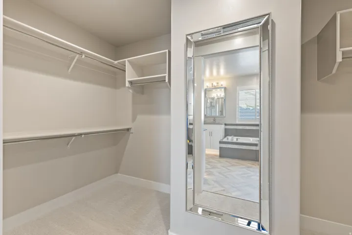 Walk-in closet with carpet flooring, built-in shelving, and hanging rods