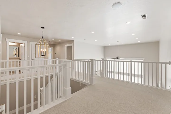 Upper-level landing featuring a wood-finish chandelier, recessed lighting, and a ceiling fan