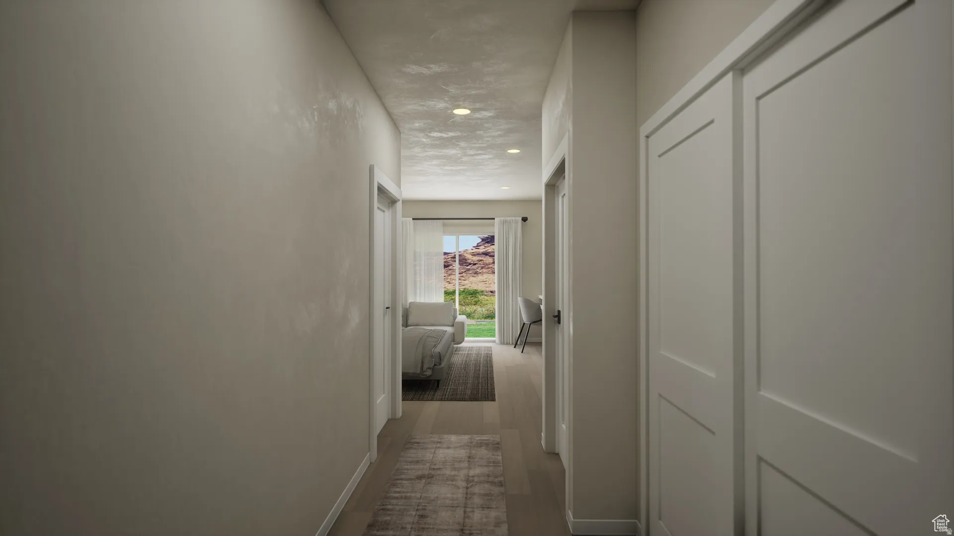 Smooth interior walls with recessed lighting and neutral wood-finish flooring