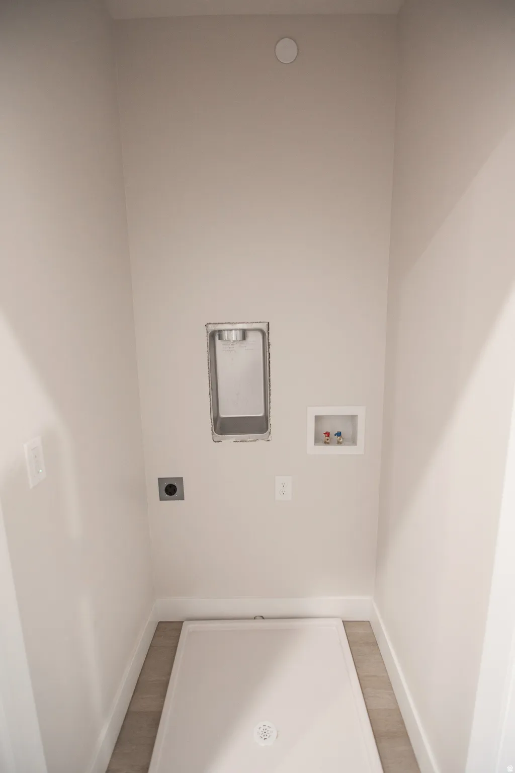 Dedicated utility area featuring a drain pan, water hookups, and a dryer vent