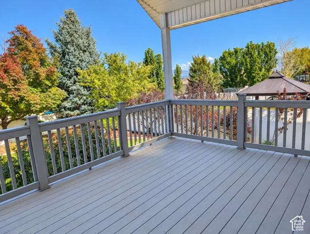 Covered deck featuring composite decking, gray railing, and mountain backdrop