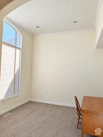 High ceilings featuring recessed lighting, extensive crown molding, and a prominent arched window