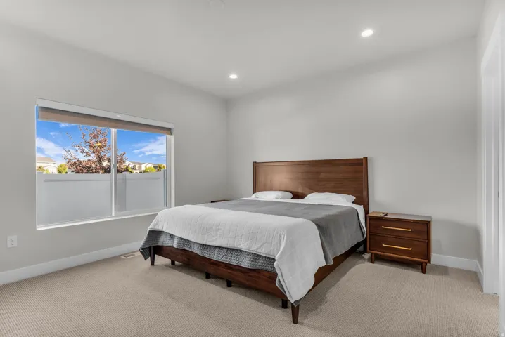 Recessed ceiling lighting, light gray wall paint, large window, beige carpet flooring, white trim