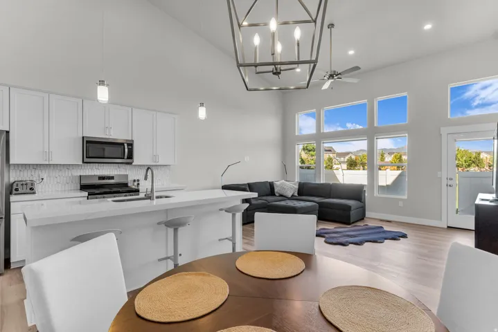 Vaulted ceiling with a contemporary chandelier, recessed lighting, and a ceiling fan