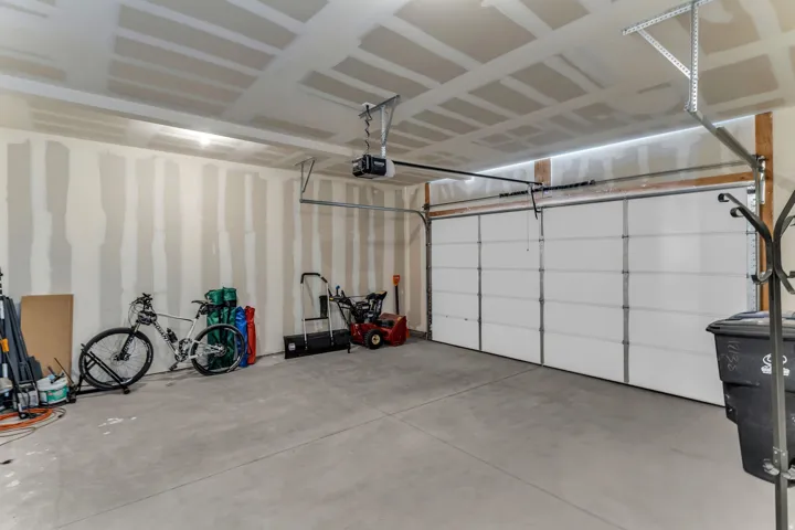 Attached garage with concrete flooring, automatic garage door opener, and overhead lighting