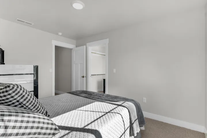 Recessed ceiling light, neutral wall paint, white trim, solid core interior door, and carpet flooring