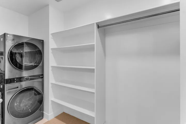 Integrated laundry appliances, built-in shelving, and a hanging rod