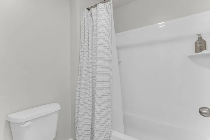 White tub-shower combination with integrated shelving