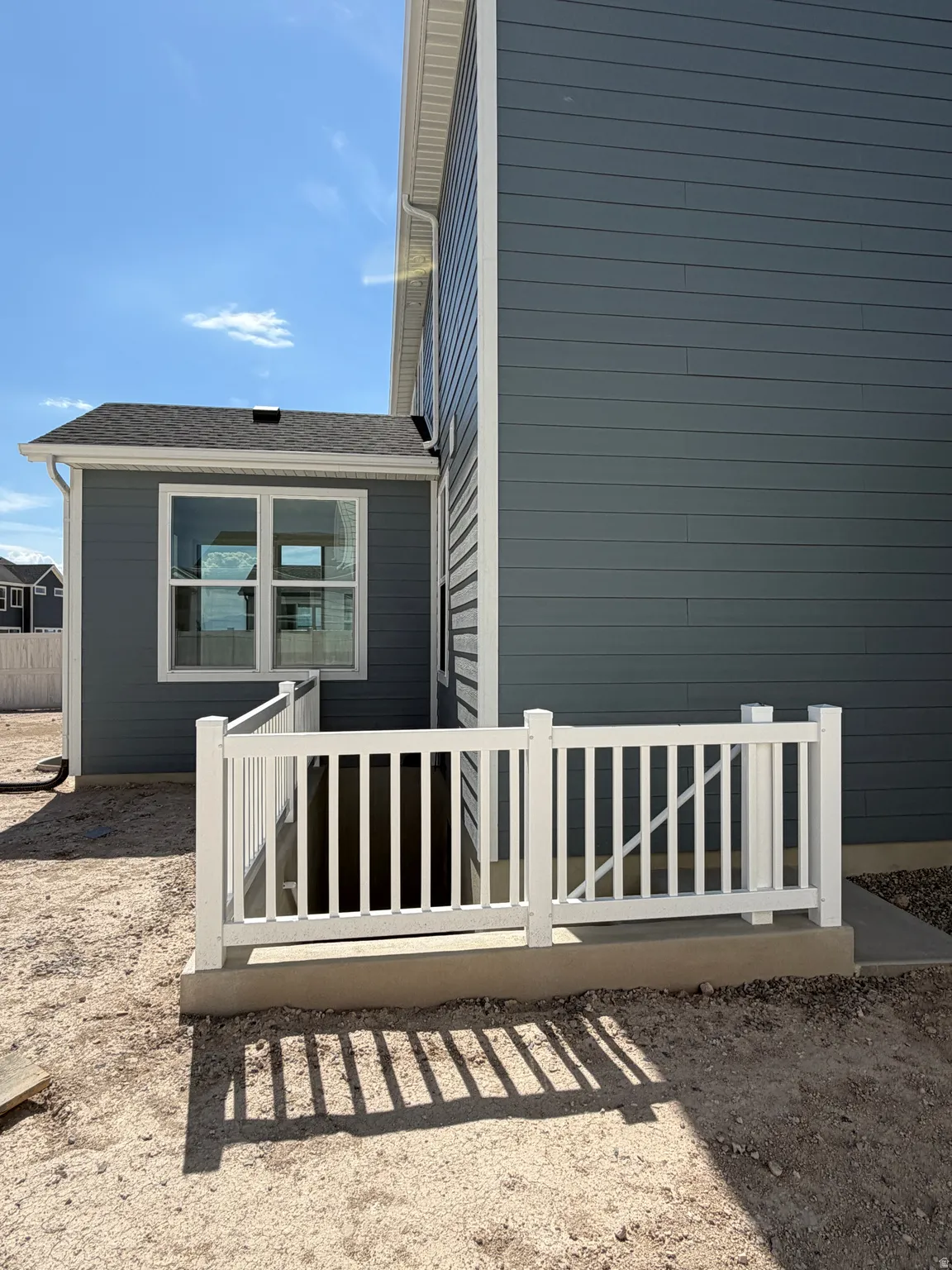 Basement separate entrance. Exterior wall with horizontal siding, white trim, and a white handrail