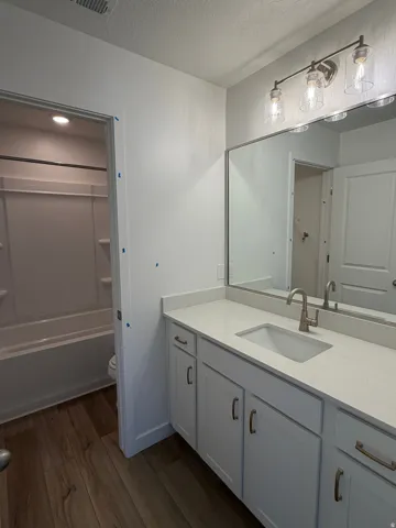 Double vanity with a rectangular sink, light-colored countertop, and modern hardware