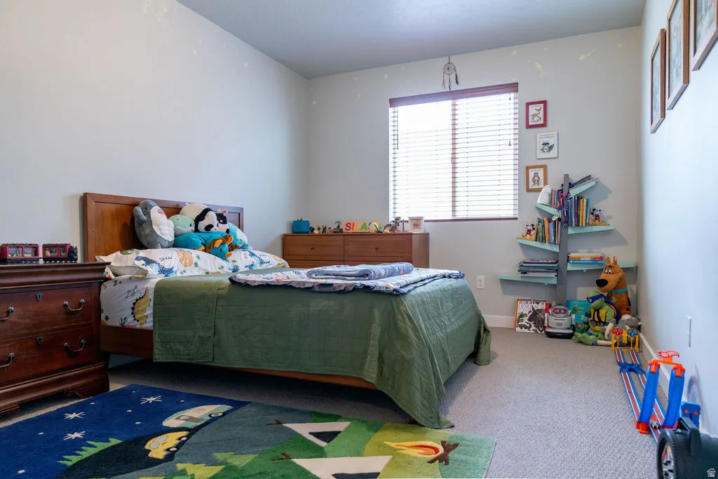 Carpeted flooring, window with blinds, and light-colored walls