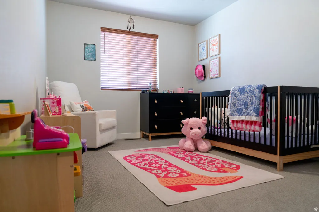 Wall-to-wall carpeting and a window with wood-finish blinds