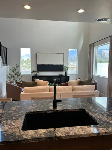 Kitchen island with patterned stone countertop, undermount sink, and matte black faucet