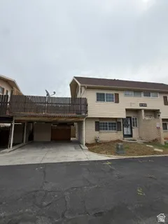 Two-story exterior with a covered parking area, second-story balcony, and brick veneer accents