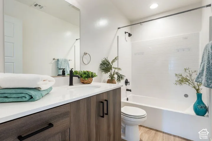 Modern bathroom featuring a wood-finish vanity with a white countertop and rectangular undermount sink