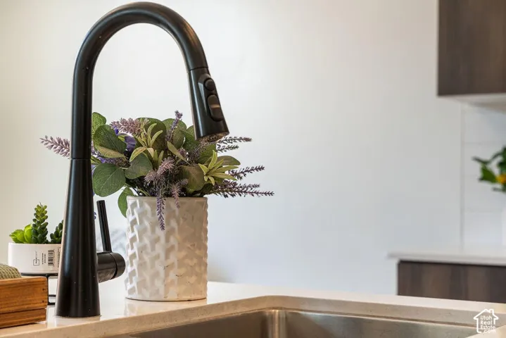Stainless steel undermount sink with a matte black pull-down faucet, set into a light-toned countertop