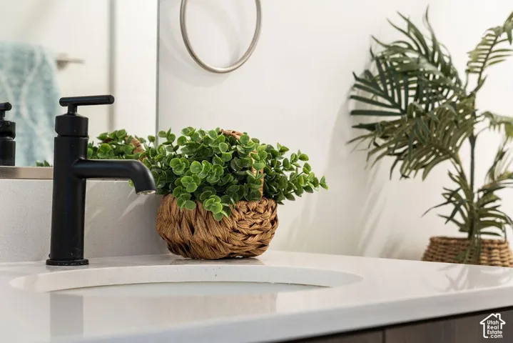 Modern primary bathroom featuring a white quartz countertop, matte black single-lever faucet, and integrated sink basin