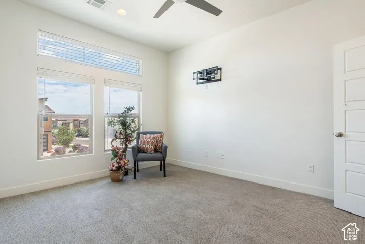 Recessed lighting, ceiling fan, carpeting, panel door, and large windows with horizontal blinds