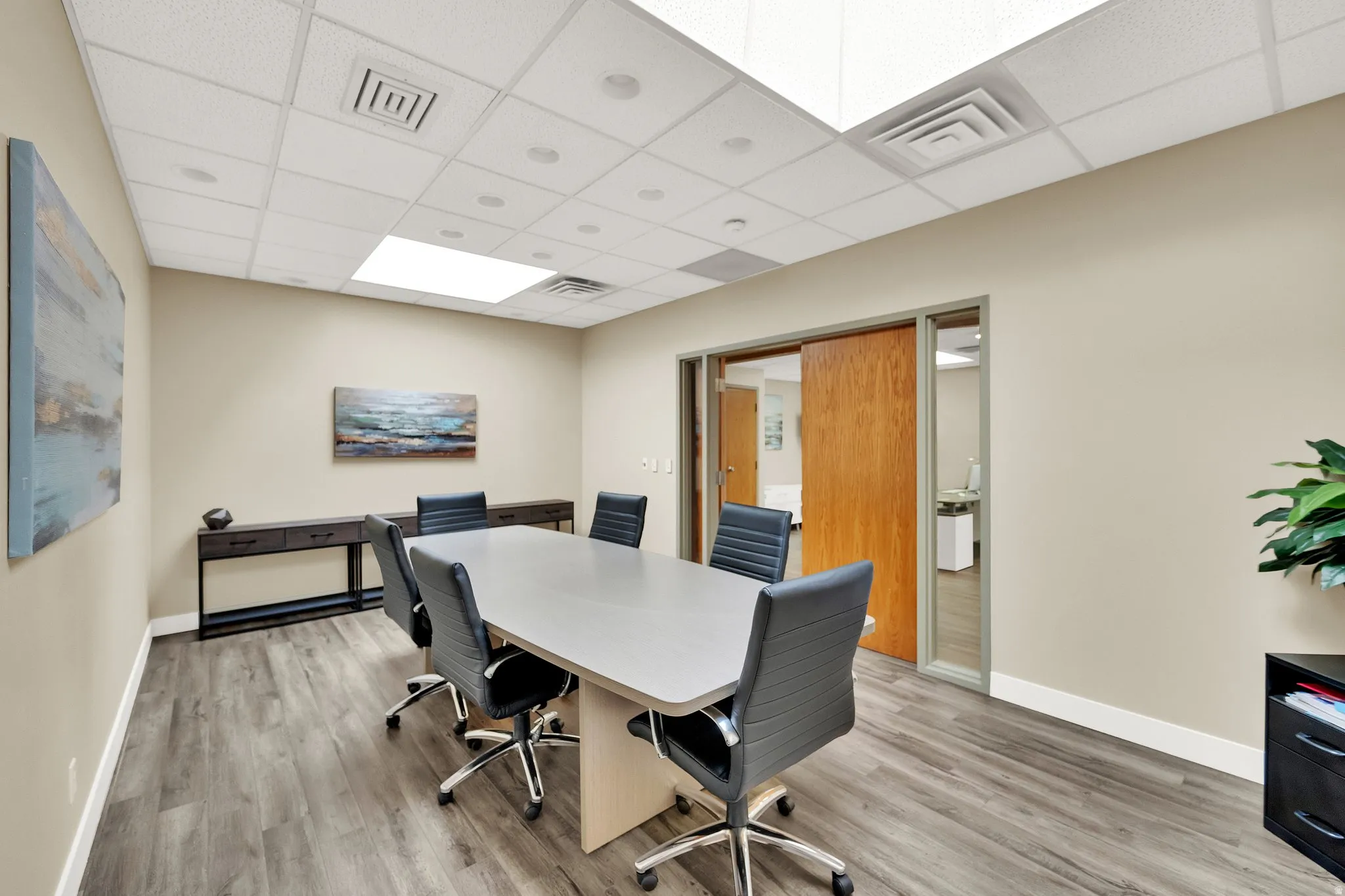 Recessed lighting, wood-finish flooring, drop ceiling, and sliding wood door
