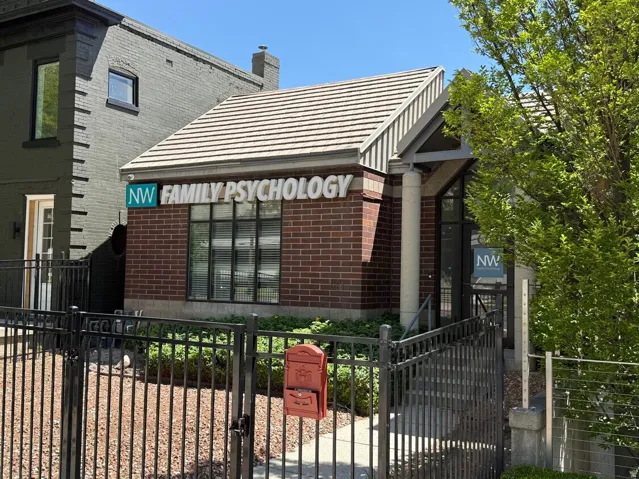 Brick facade building featuring a sloped roofline, prominent signage, and a columned entryway