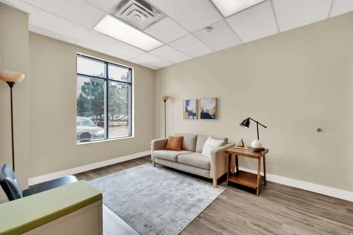 Recessed lighting with a drop ceiling, wood-finish flooring, and large window