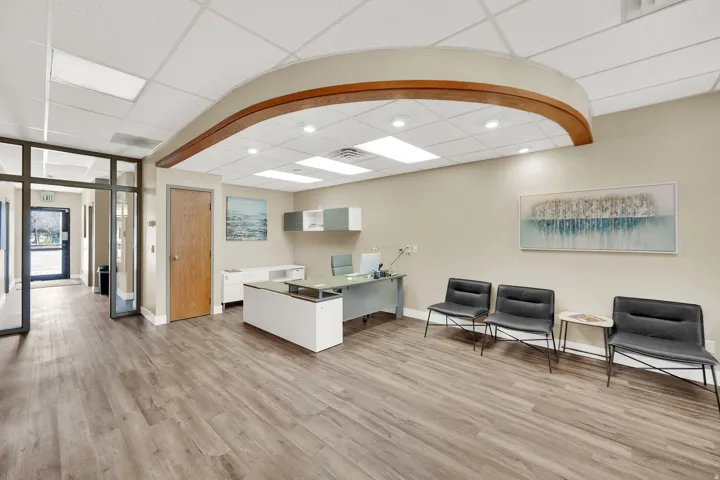 Wood-finish flooring, recessed lighting, drop ceiling, and wood-paneled door