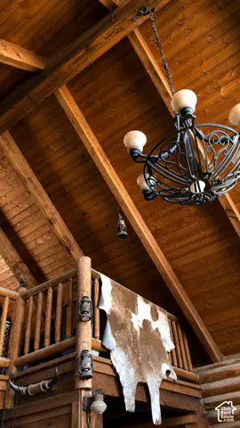 Vaulted wood-paneled ceiling with exposed wood beams and a decorative chandelier