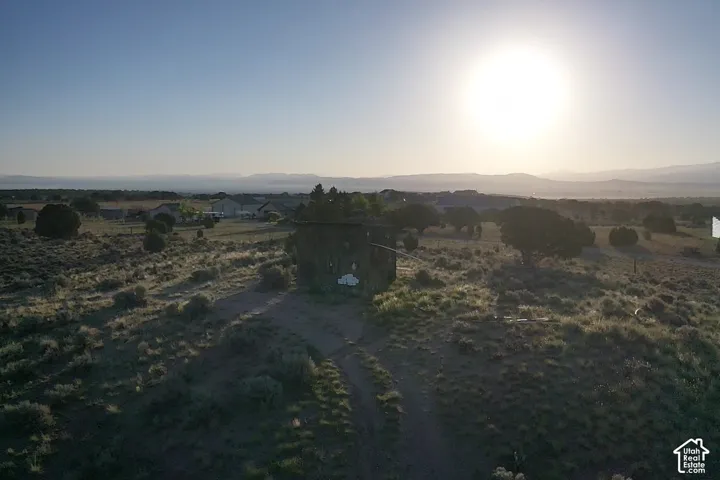 Expansive natural landscape featuring scattered mature trees and distant mountain ranges