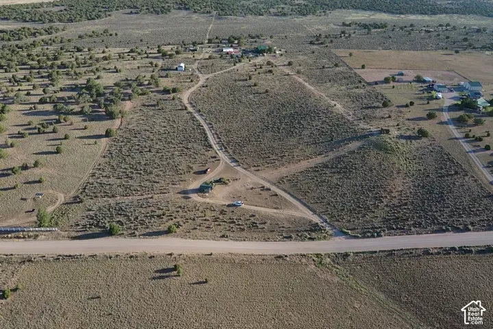 Expansive natural landscape featuring scattered trees and established dirt roads