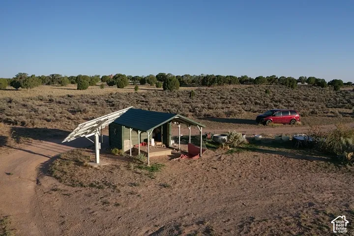 Freestanding solar panel array with a rustic outbuilding featuring a covered porch and metal roof