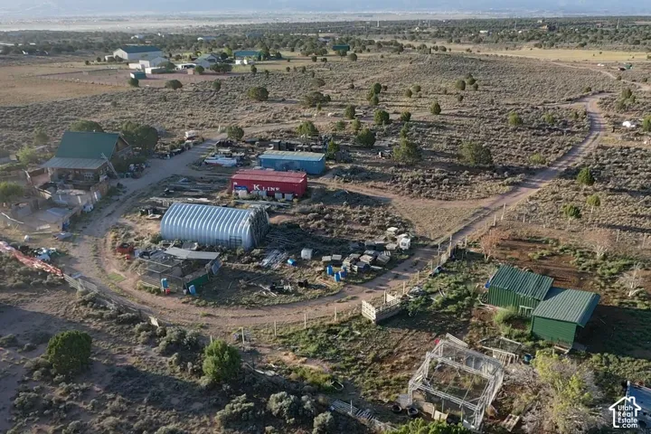 Rural setting with multiple outbuildings, including a large Quonset hut and several storage containers