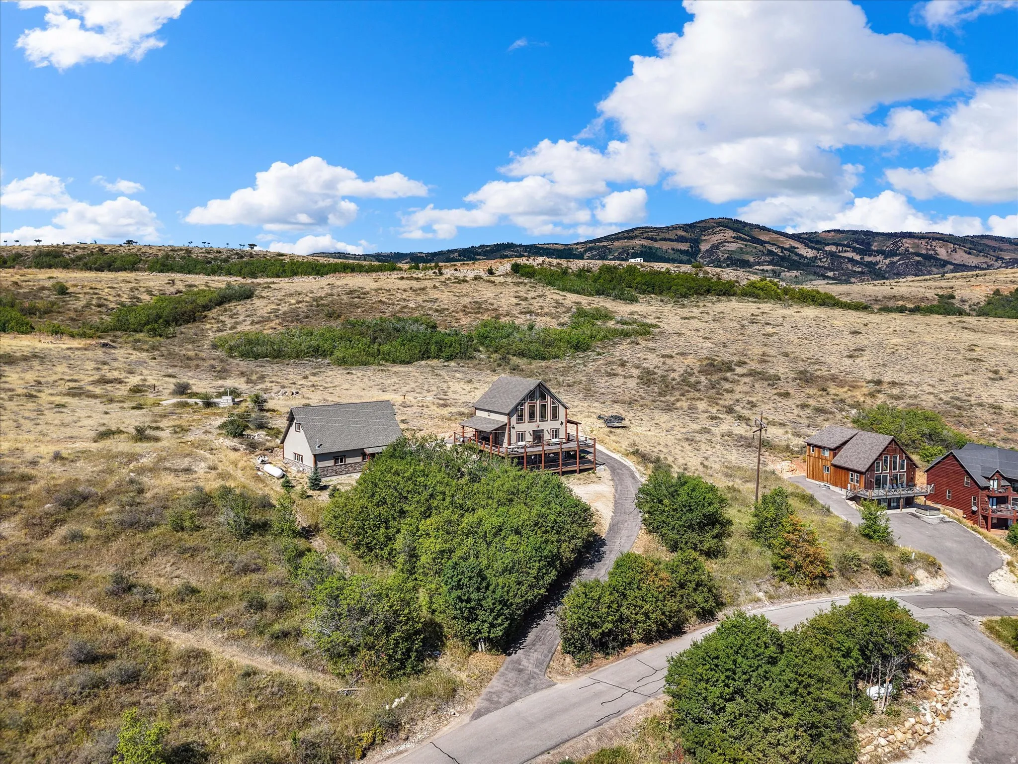 Property featuring a multi-level deck, a gravel driveway, and a natural, unlandscaped yard