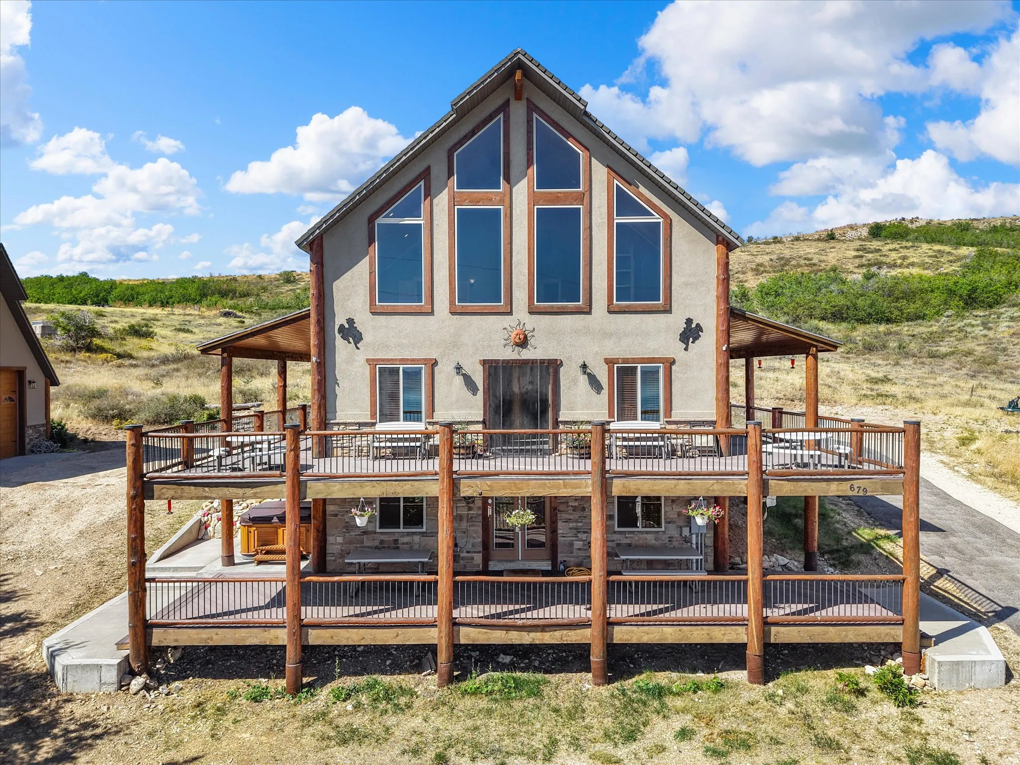 Multi-level deck with wood-finish railings, stucco exterior, and stone accents
