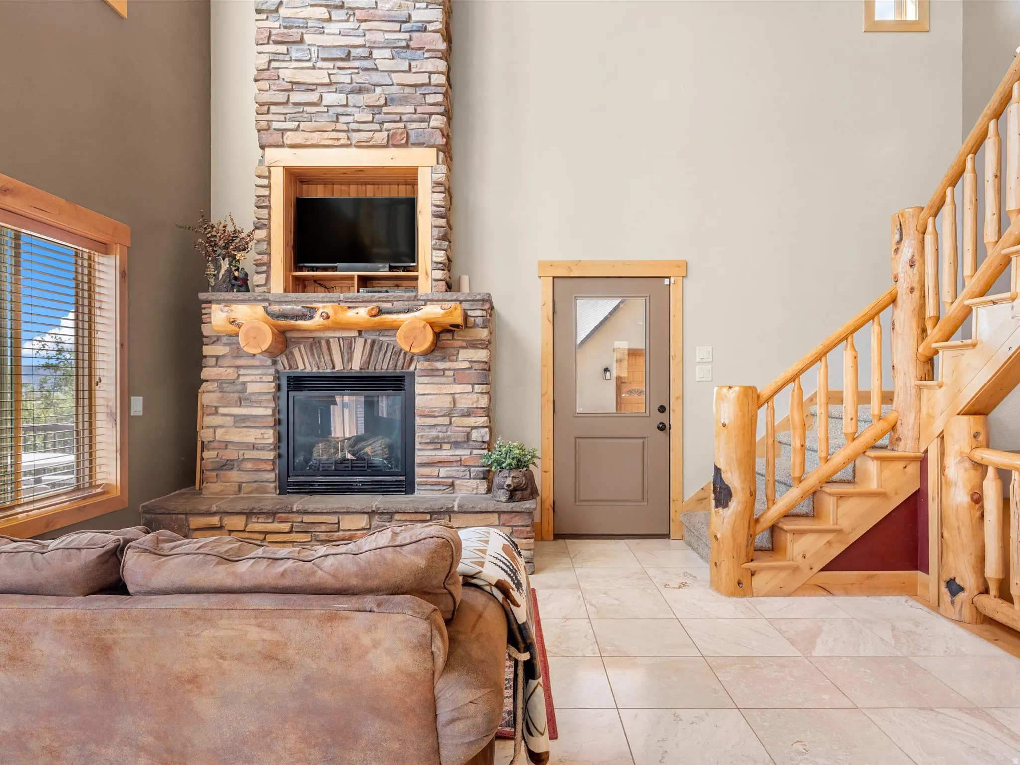 Stacked stone fireplace with a built-in media niche, wood-finish mantel, and hearth