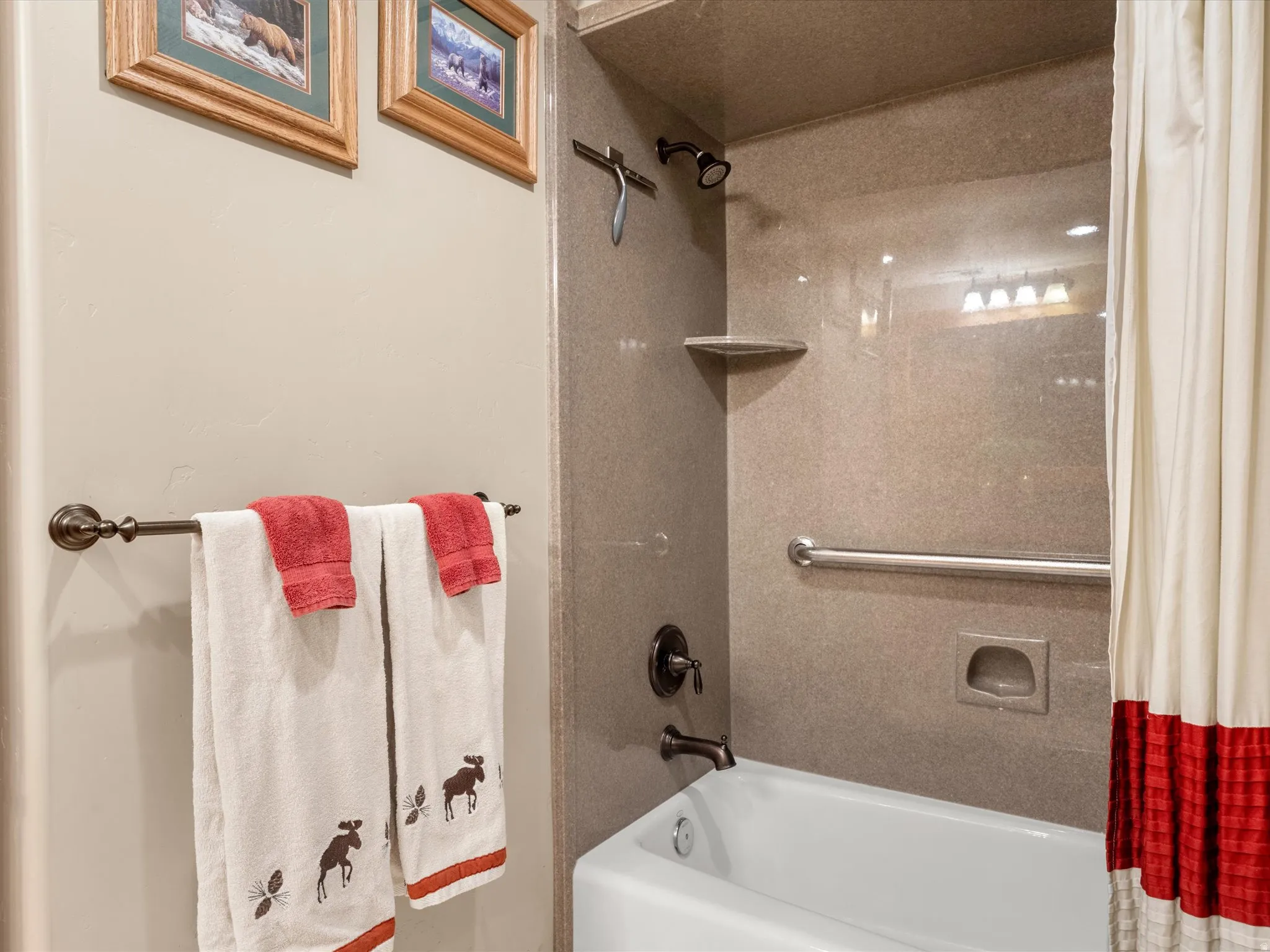 Bathtub with dark bronze fixtures, integrated soap dish, and a polished grab bar