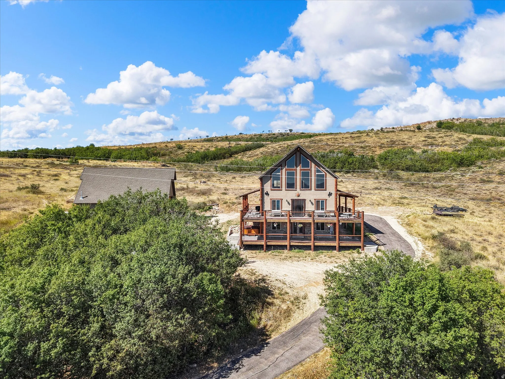 Two-story residence with a multi-level deck, a prominent gabled roofline, and extensive windowing