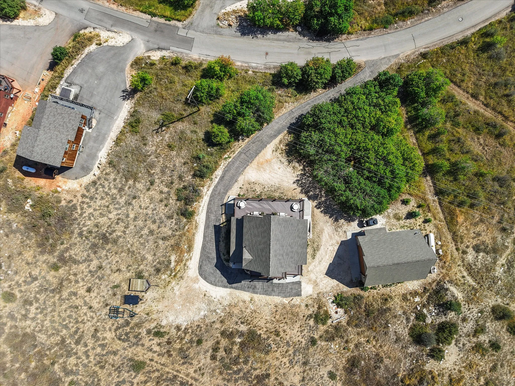Property featuring a main residence with a gabled roof, an additional detached structure, and a paved driveway