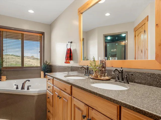 Dual vanity with wood cabinetry and stone countertops