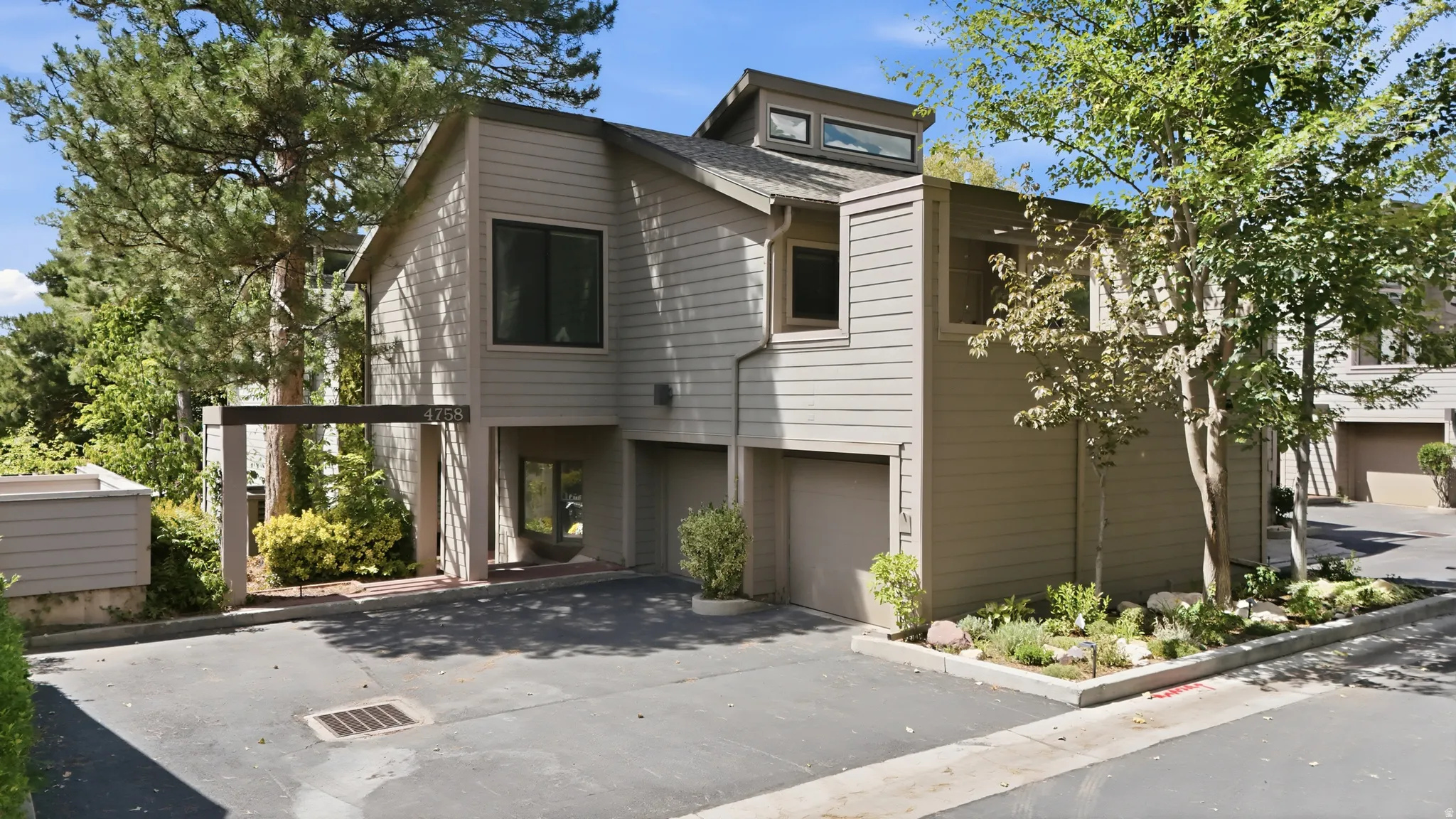 Two-story residence featuring horizontal siding, integrated garage, and mature landscaping