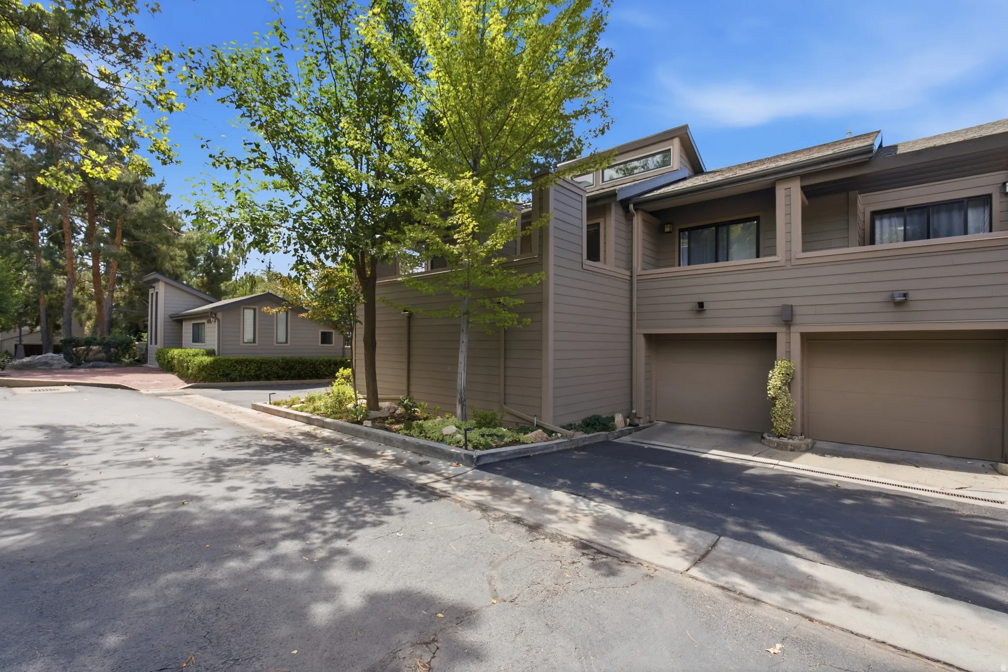Exterior featuring multiple garages, horizontal siding, and prominent rooflines