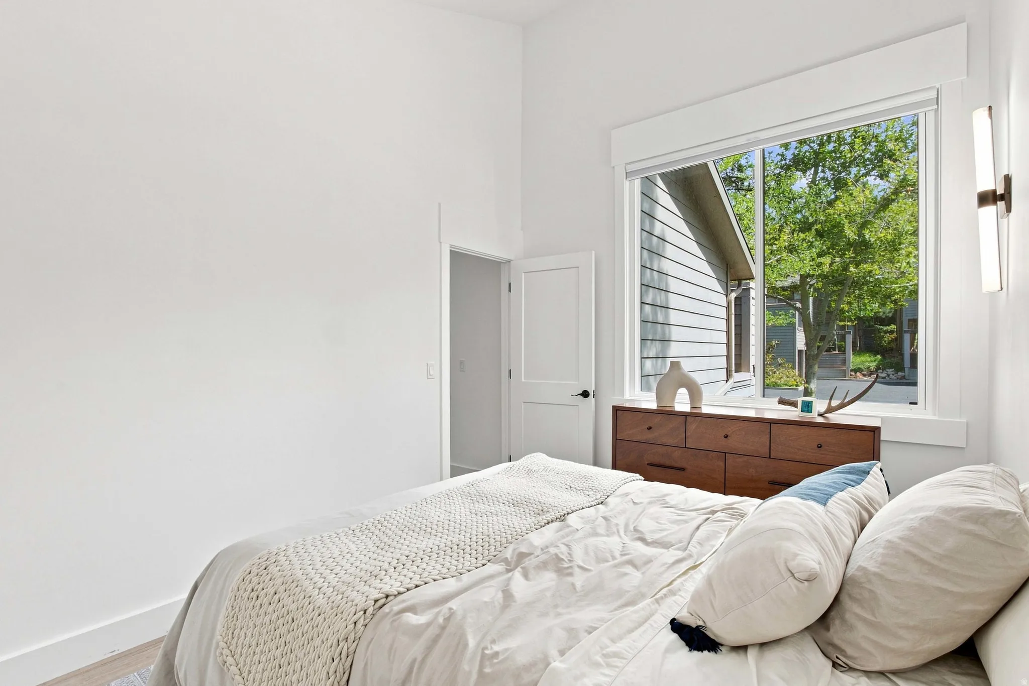 Crisp white walls with a large window featuring a surrounding window trim