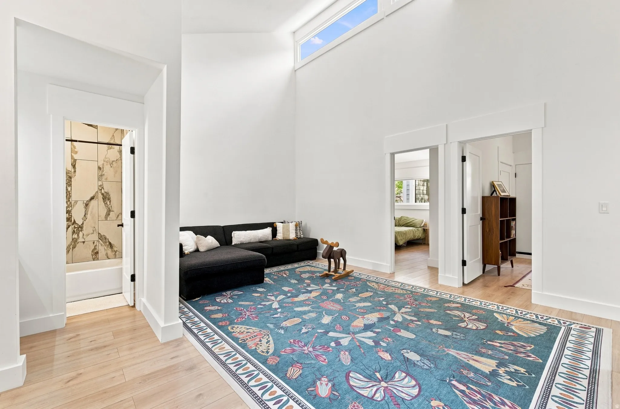 Hardwood-finish flooring, high ceilings with clerestory windows, and a built-in tub with tile surround