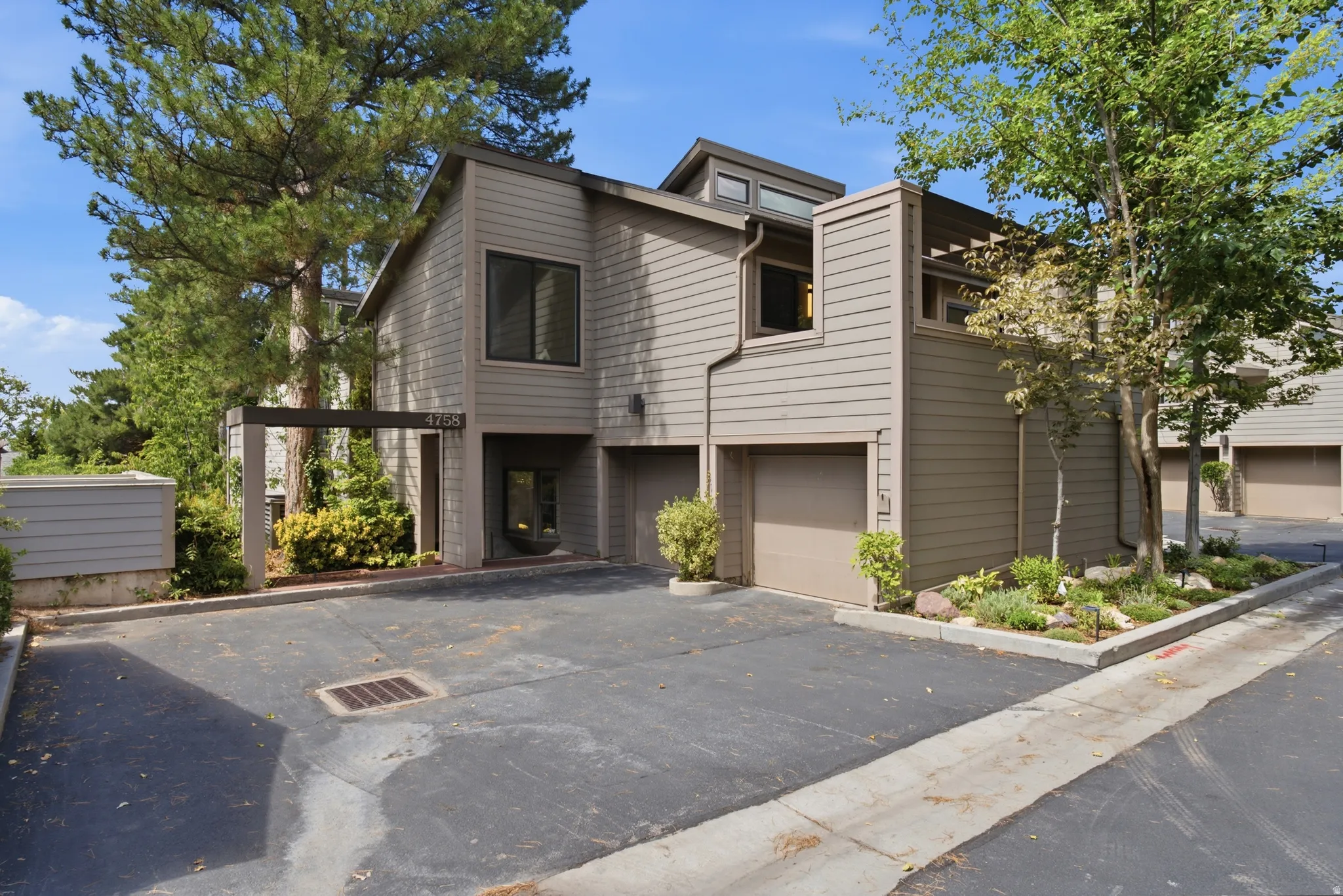 Contemporary exterior with horizontal siding, an integrated garage, a covered entry, and established perimeter landscaping