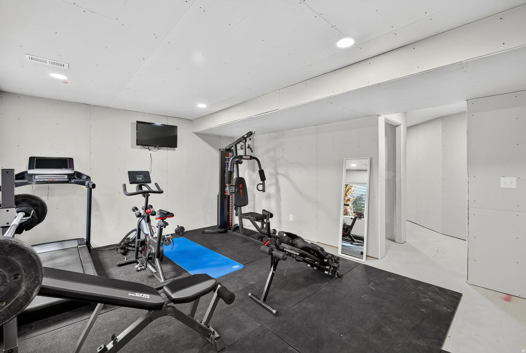 Open-concept space with recessed lighting and neutral wall finishes