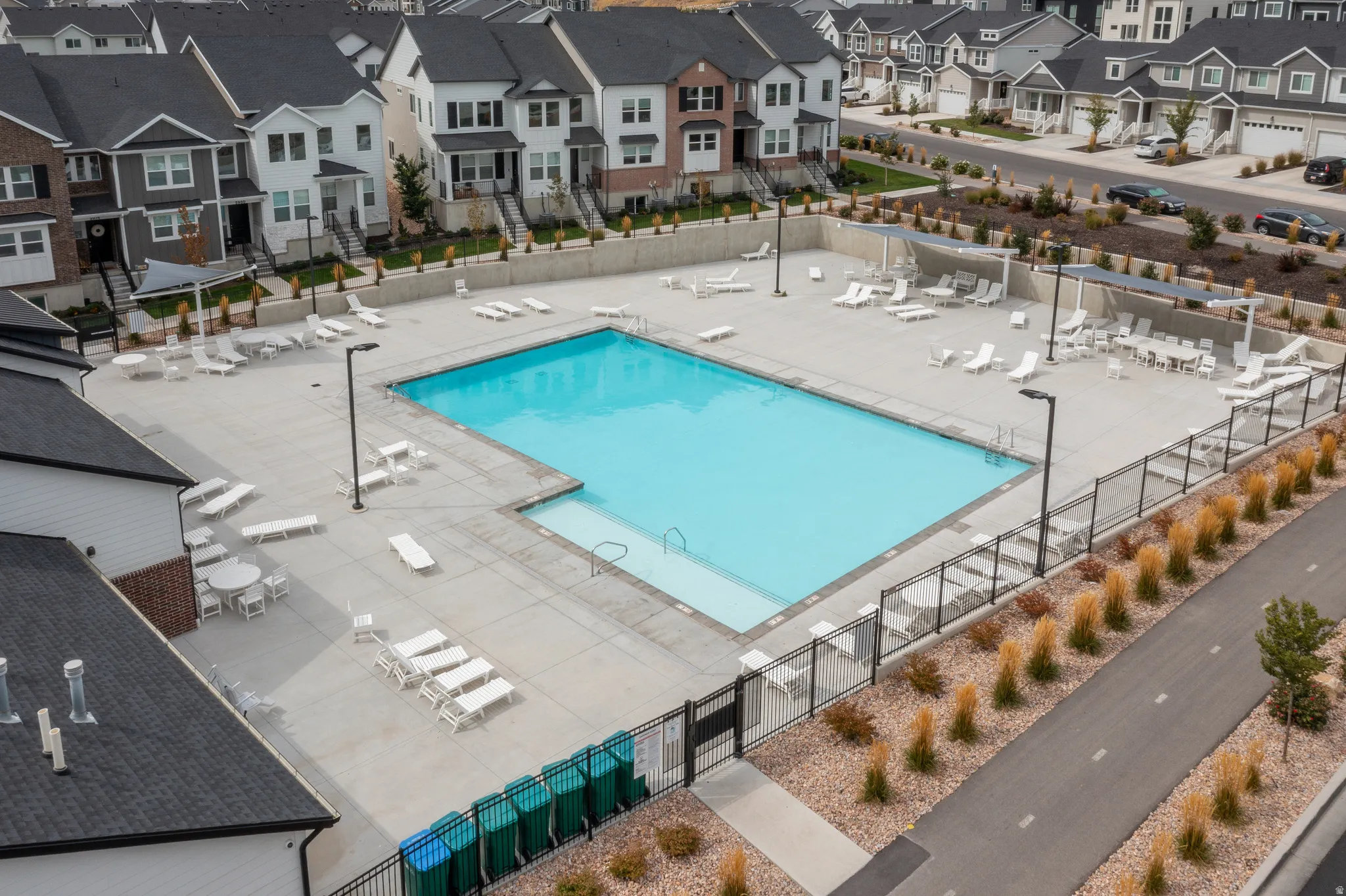 Community outdoor swimming pool with surrounding concrete patio