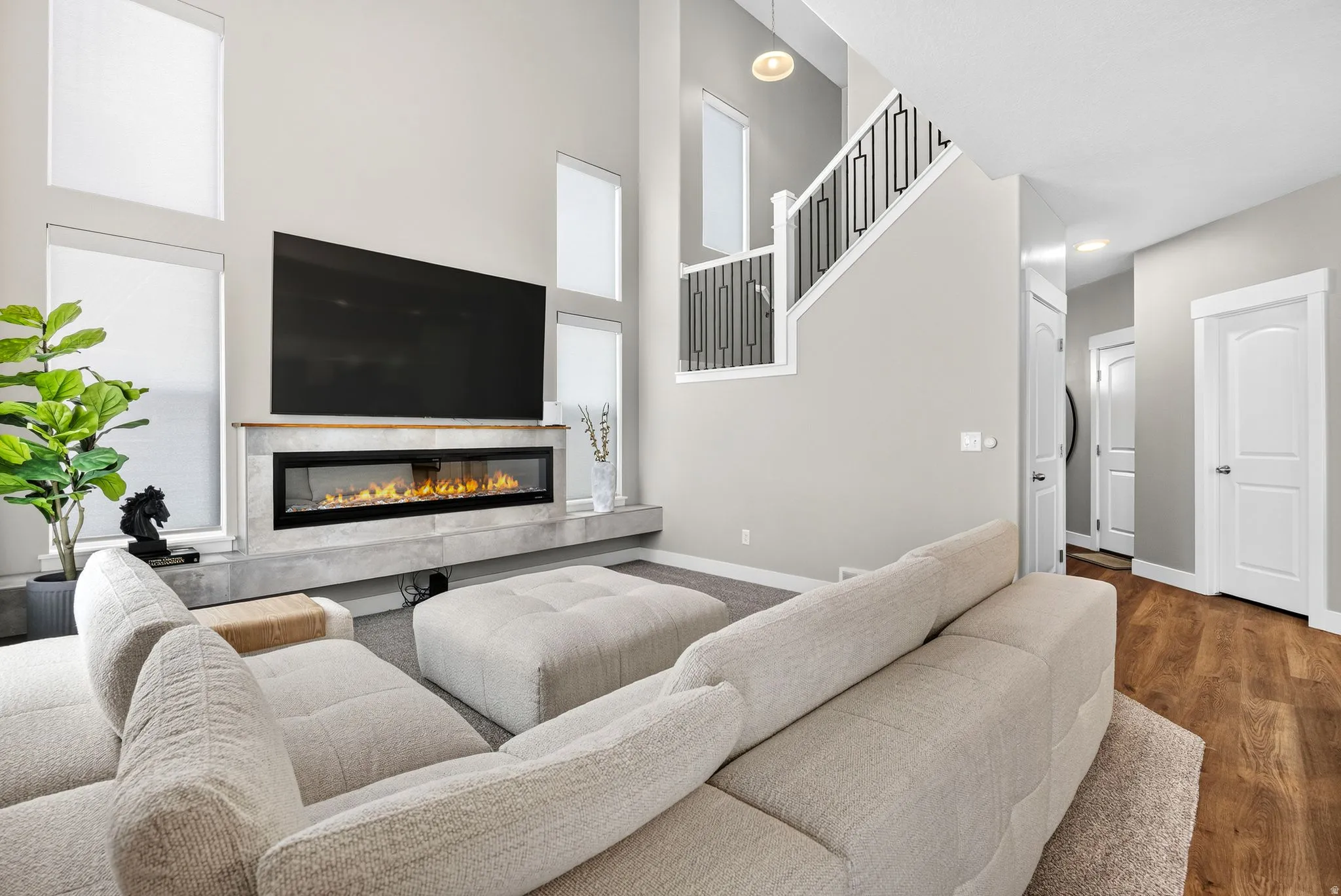 Vaulted ceiling with an integrated linear fireplace, a floating mantel, and multiple tall windows