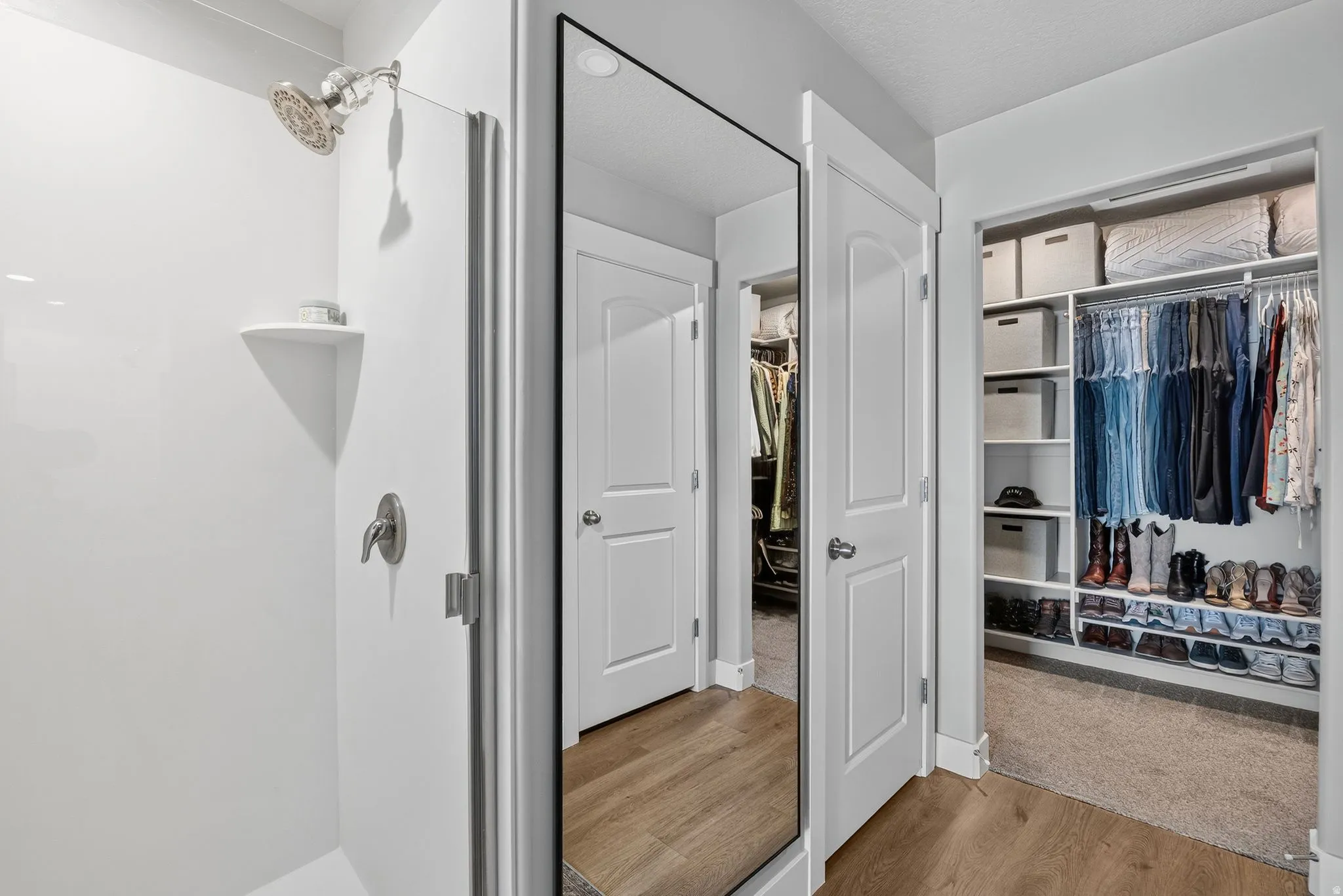 Walk-in shower with a chrome shower head and built-in shelving