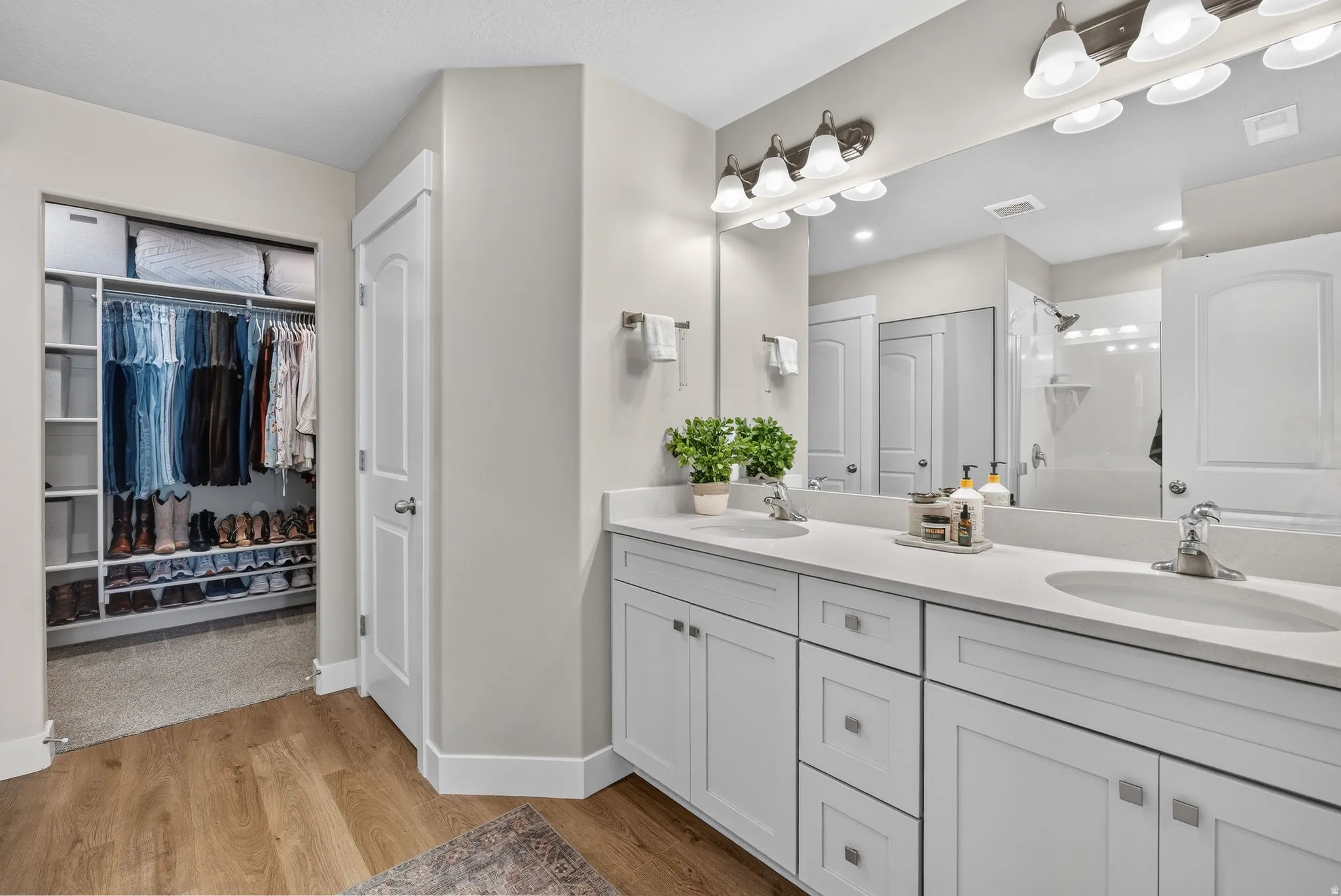 Dual vanity with undermount sinks, white cabinetry, and light-toned countertops